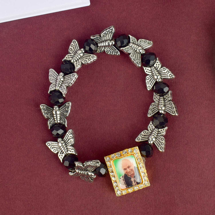 Chic Guruji Swaroop Bracelet featuring black beads and silver butterfly charms, handcrafted for spiritual elegance and daily devotion. India’s Largest Pooja Accessories Brand – www.satvikstore.in