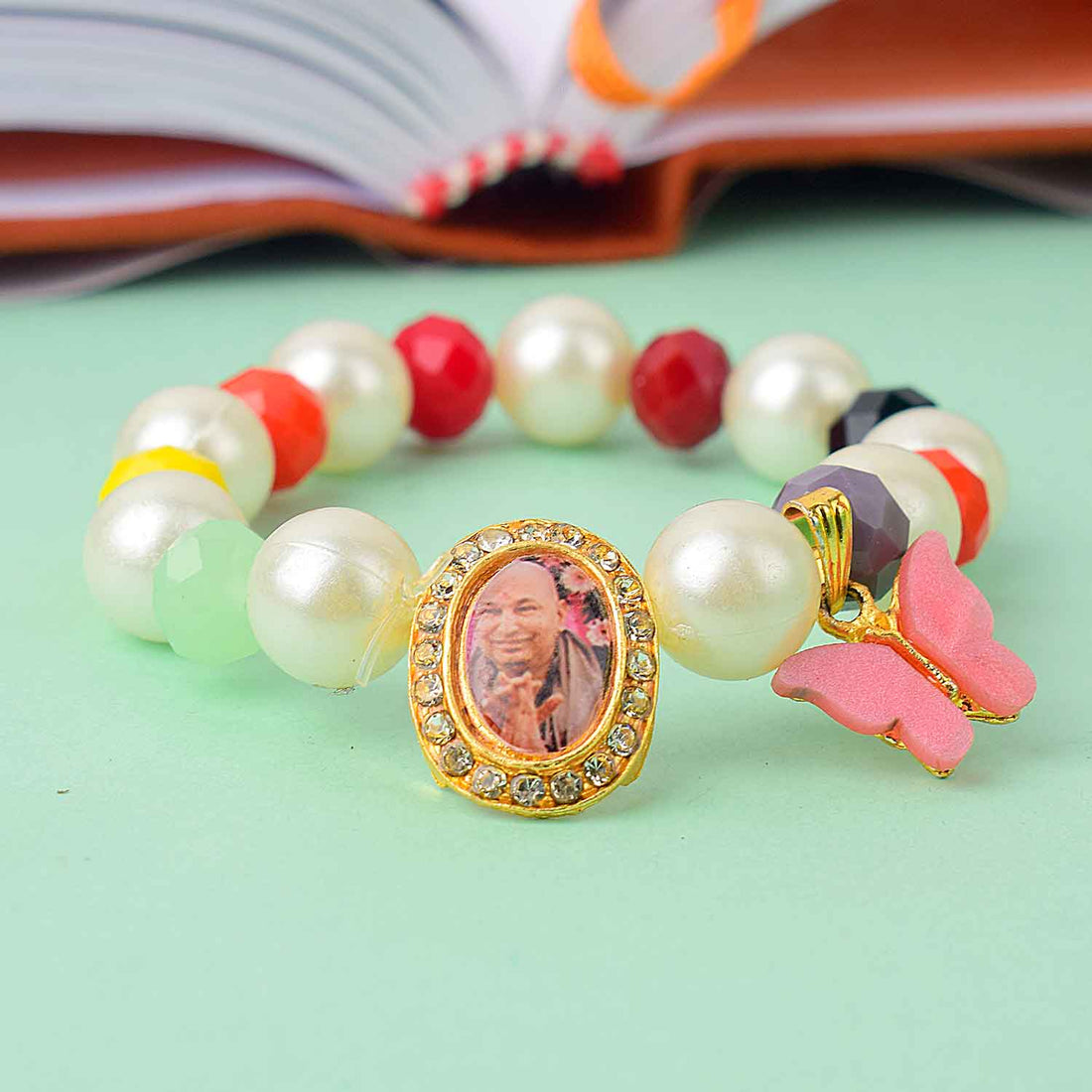 Guruji Swaroop Bracelet with pearls, multicoloured beads, and butterfly charm – ideal for satsangs, spiritual wear, or gifting. India’s Largest Pooja Accessories Brand – www.satvikstore.in