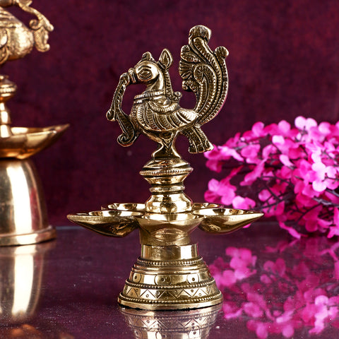 A beautifully crafted Peacock Panchmukhi Brass Diya, showcasing intricate peacock design with five flames. This traditional diya brings a touch of elegance and spirituality to your home or temple during religious ceremonies and festivals. Indiaβs Largest Pooja Accessories Brand β www.satvikstore.in